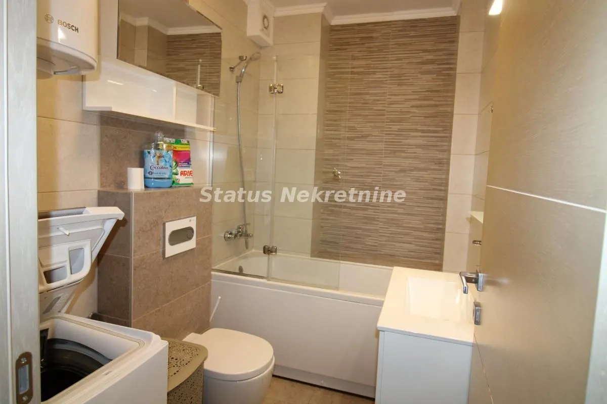 Bathroom equipped with a bathtub, washbasin, toilet, and washing machine.