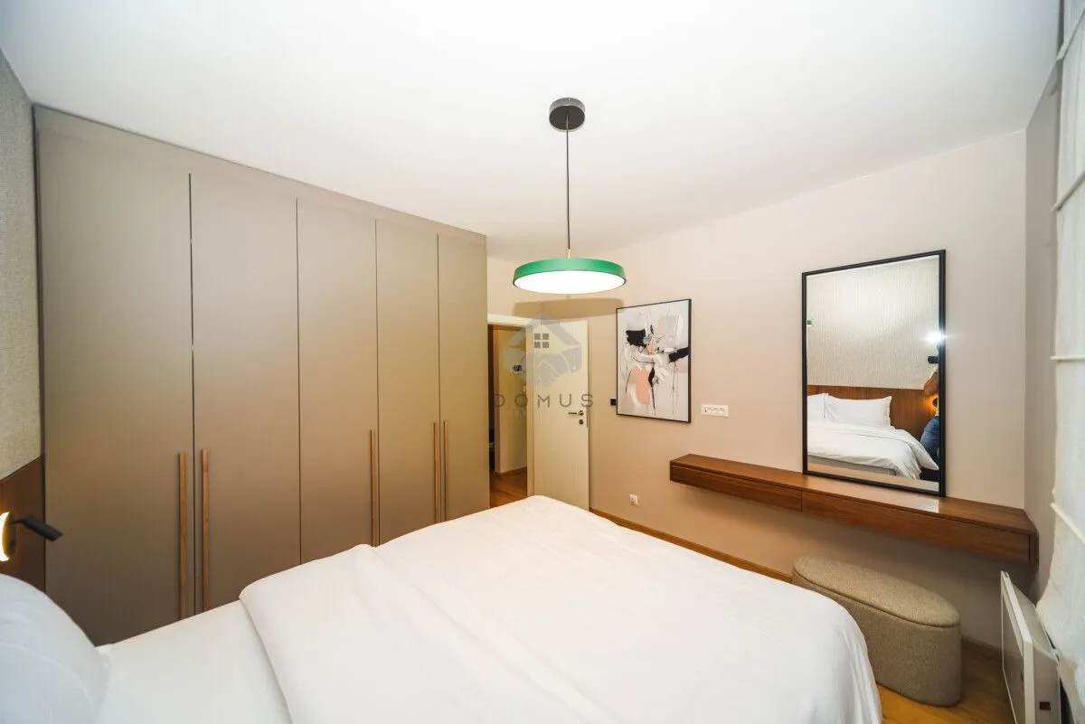 Modern bedroom with a double bed, built-in wardrobe and mirror.