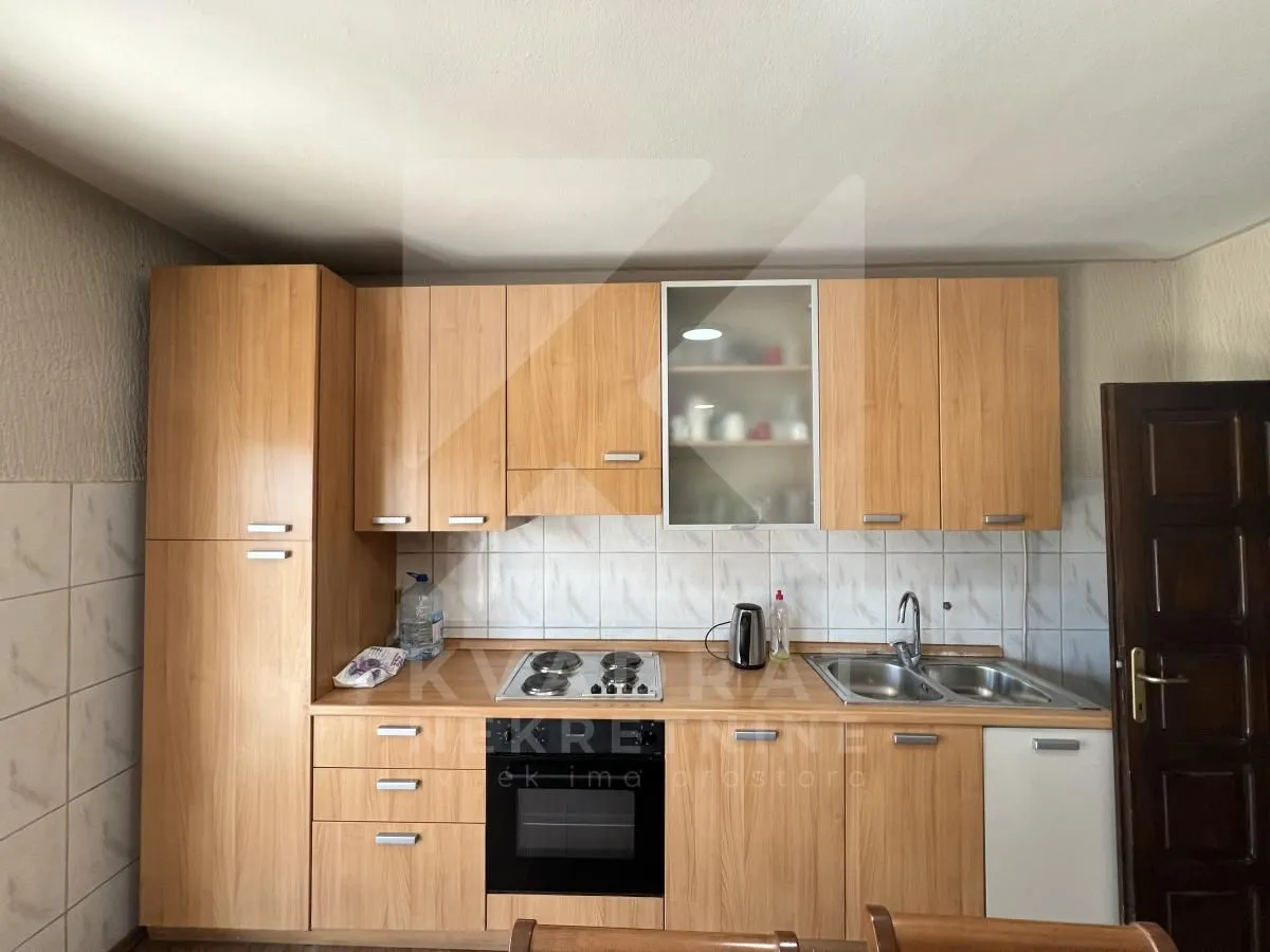 Wooden kitchen units with built-in oven, hob and sink.