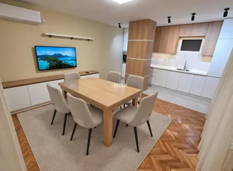 Dnevna soba sa trpezarijom i ugrađenom kuhinjom u pozadini. - image 3