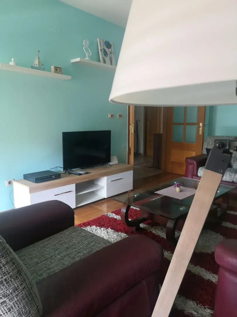 Dnevna soba sa svijetlo plavim zidom i televizorom.