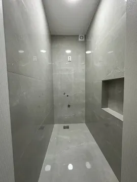 Prazno kupatilo obloženo sivim pločicama sa ugradnom nišom. - image 12