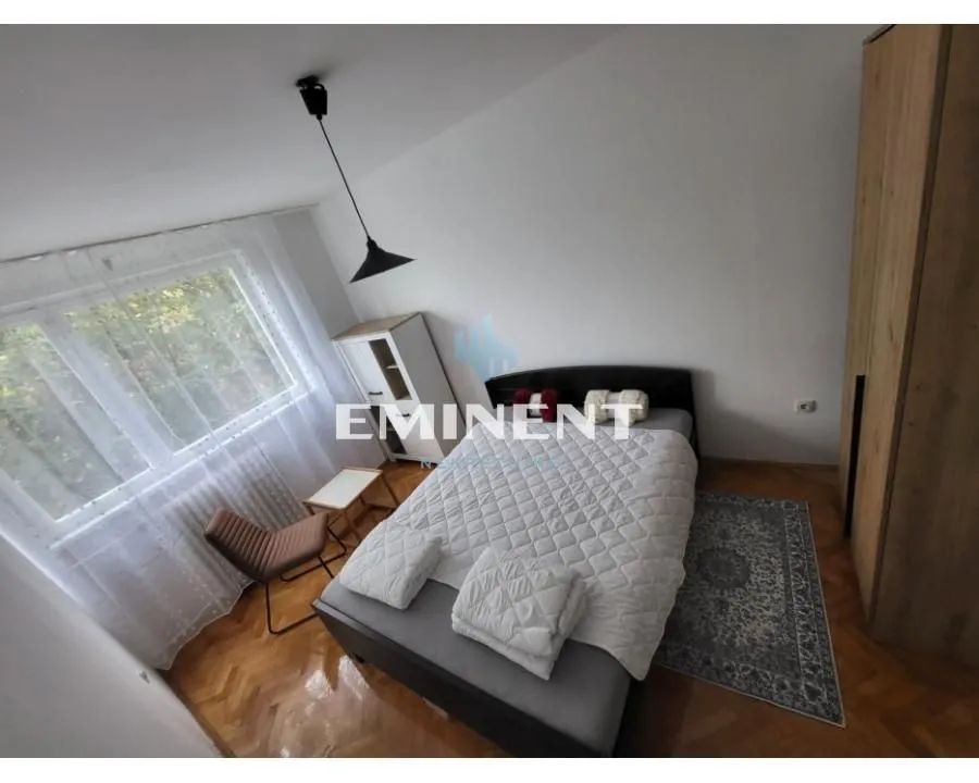 Furnished bedroom with a double bed, wardrobe, and a window.
