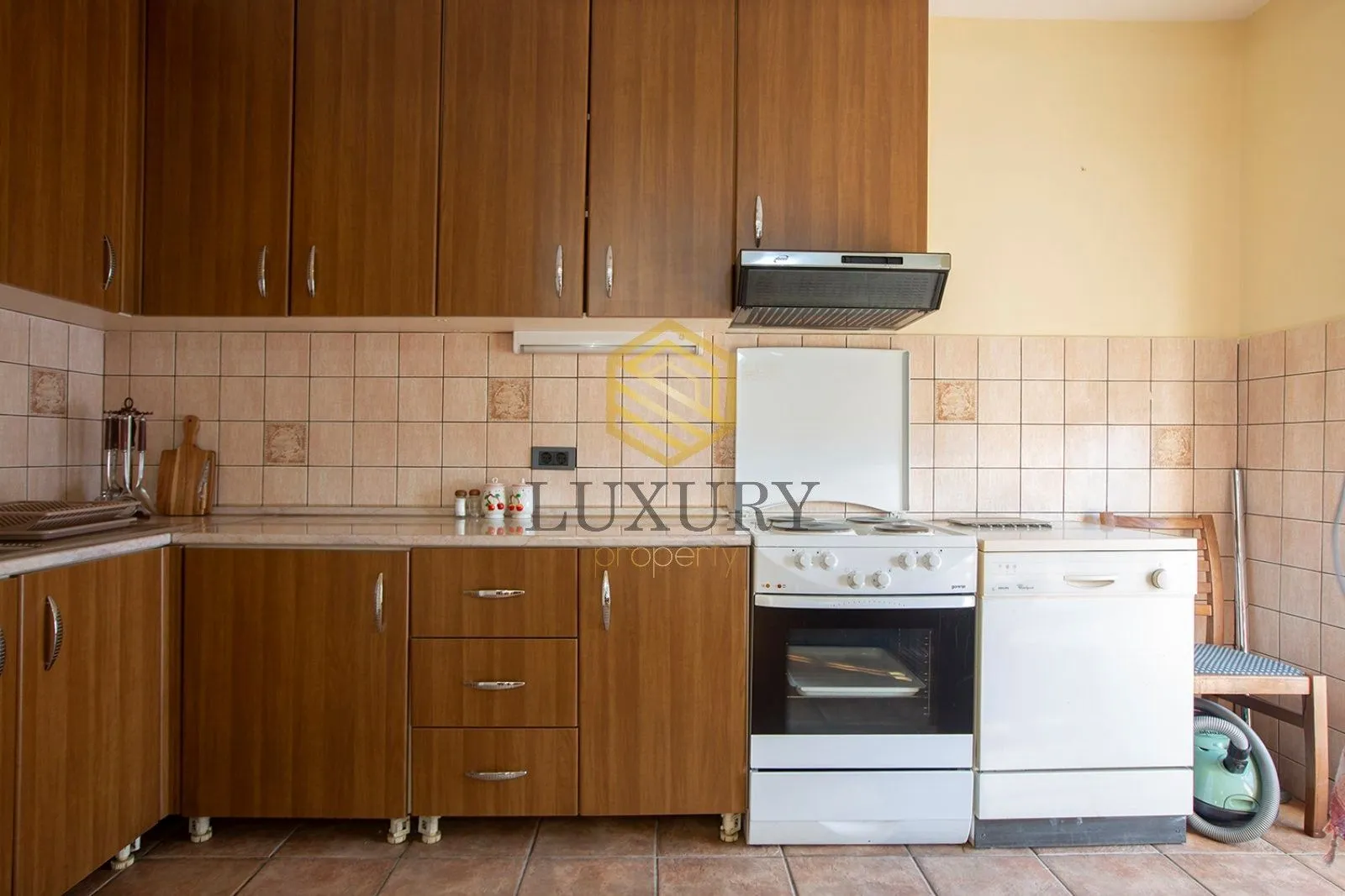 Kitchen with wooden cabinetry, stove, and dishwasher.