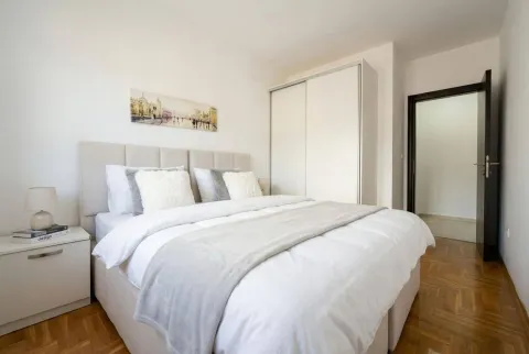Furnished bedroom with a double bed, wardrobe, and parquet flooring. - image 7