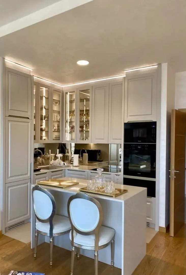 Modern kitchen with white cabinetry, an island, and built-in appliances.