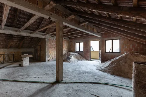 Potkrovlje u izgradnji sa drvenom krovnom konstrukcijom i gomilama građevinskog materijala. - image 10
