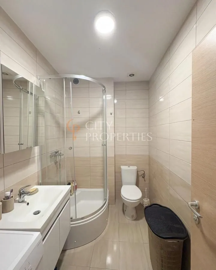 Compact bathroom with a shower cabin, washbasin, and toilet.