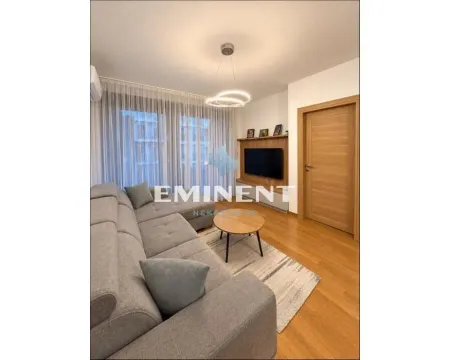 Living room with a sofa, coffee table and wall-mounted TV. - image 2