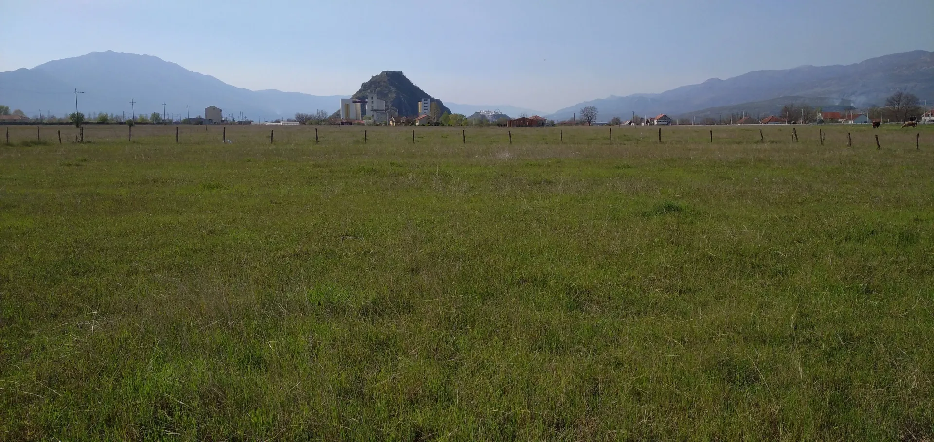 Pogled na prostrano zemljište sa planinama u pozadini.