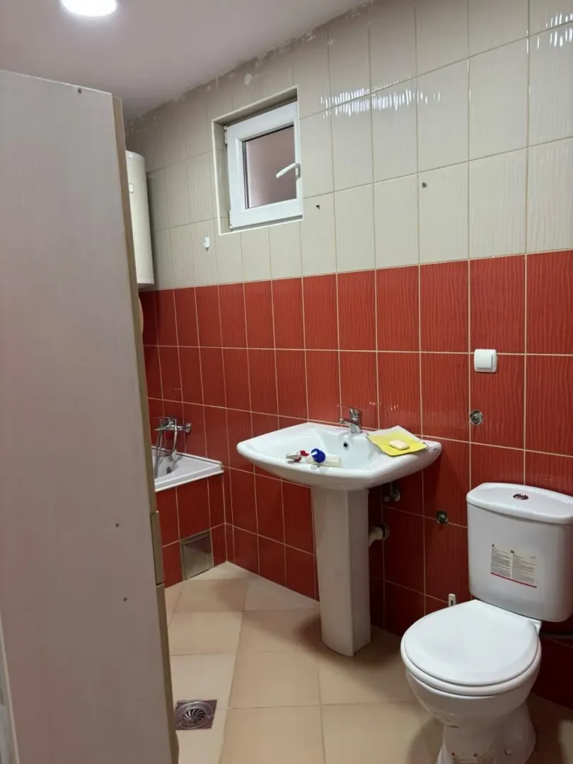 Bathroom with a sink, toilet, and bathtub, tiled with ceramic tiles.