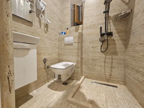 Kompaktno kupatilo obloženo keramičkim pločicama sa tuš kabinom i ugradnim WC šoljom. - image 9