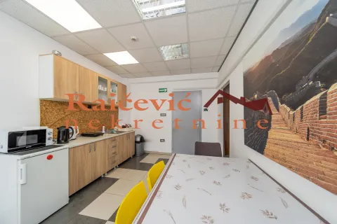 Kitchen with wooden cabinetry, a small refrigerator, and a dining table with yellow chairs. - image 4