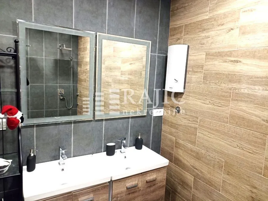 Modern bathroom with double sink and large mirrors.