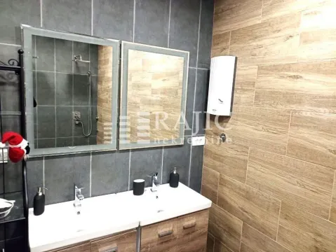 Modern bathroom with double sink and large mirrors. - image 10