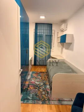 Manja spavaća soba sa krevetom i plavim ormarom. - image 3