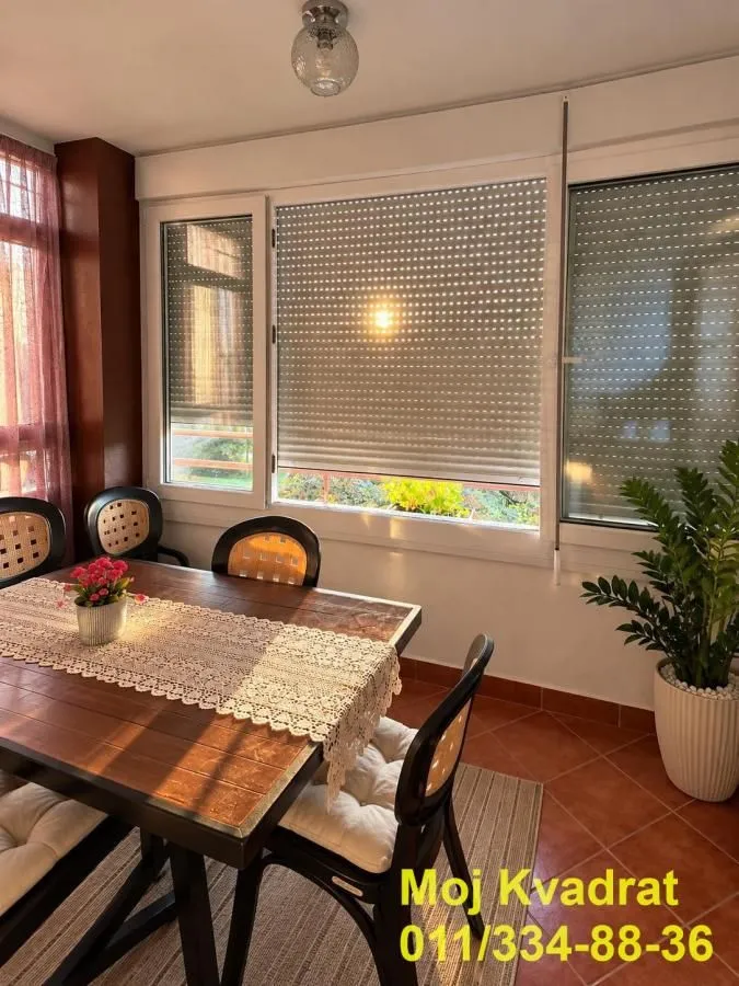 Enclosed terrace with a dining table and chairs.