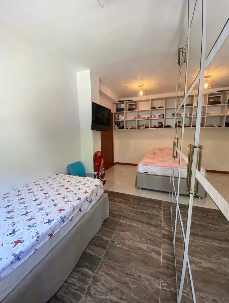 Children's bedroom with two beds and a large mirrored wardrobe.