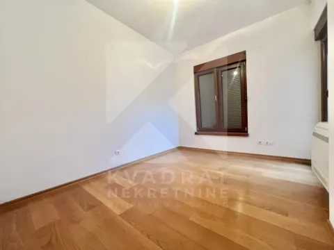 Prazna soba sa bijelim zidovima i drvenim podom. - image 6