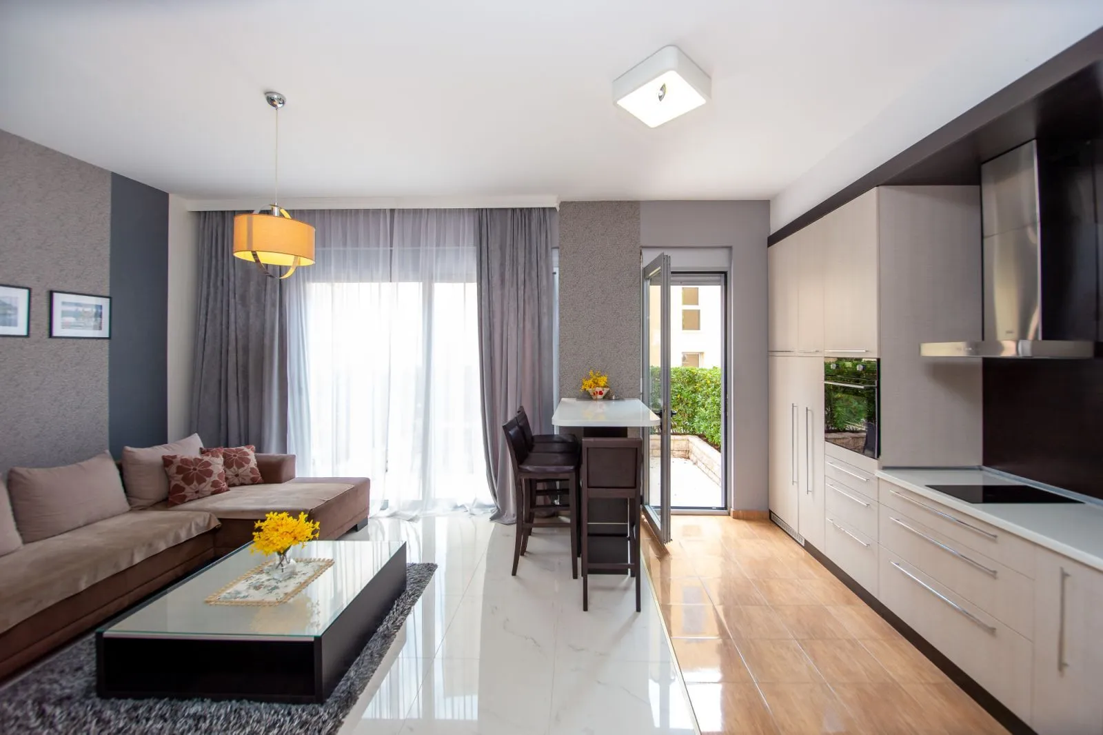 Living room with a sofa and dining area connected to the kitchen.