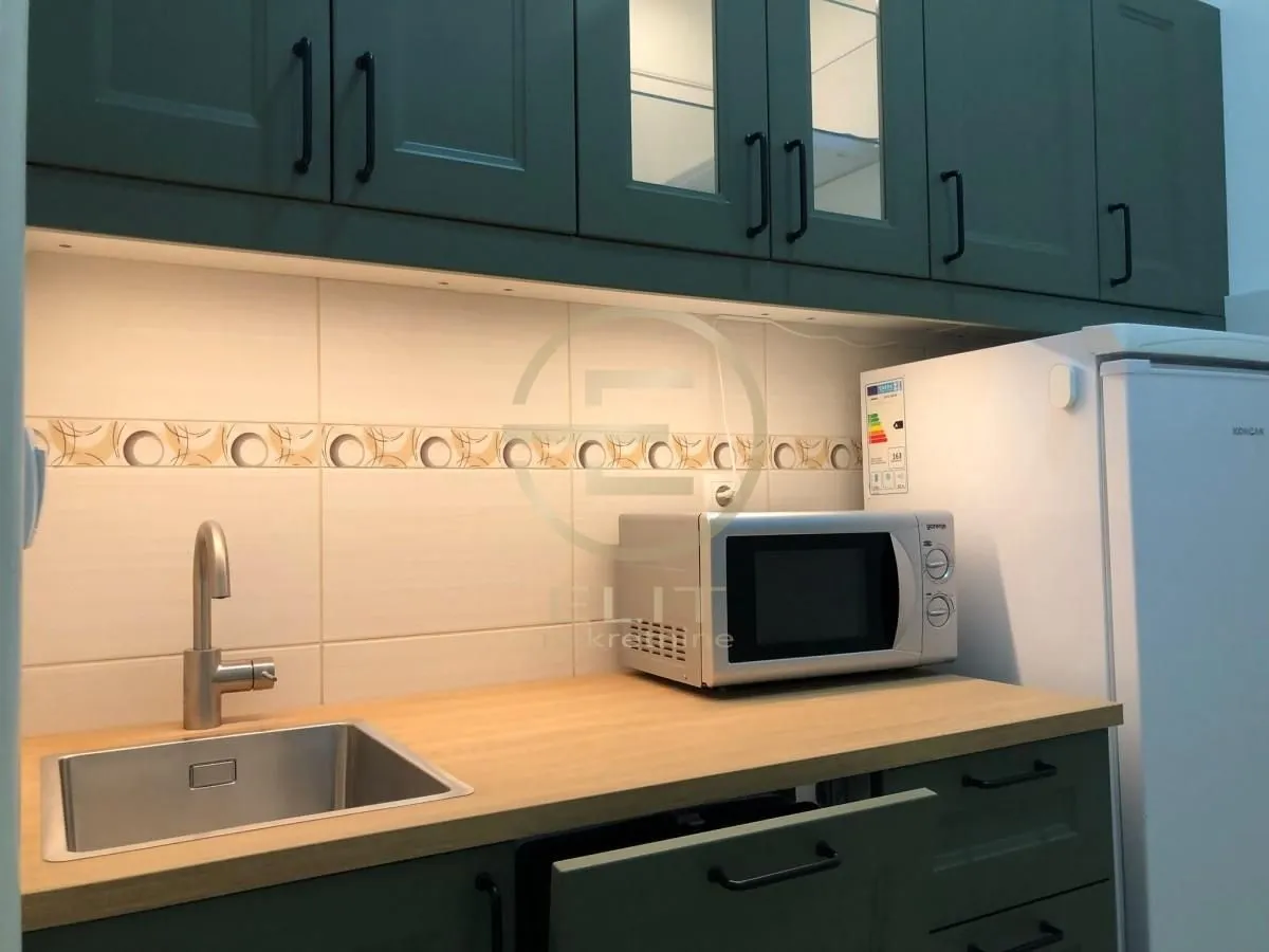 Part of the kitchen with a sink, countertop, microwave, and refrigerator.