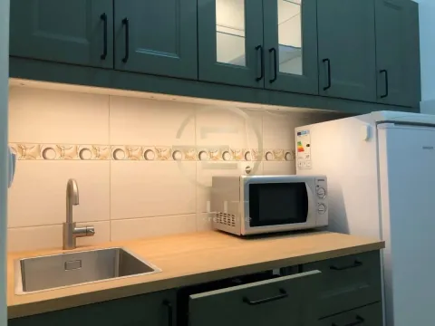Part of the kitchen with a sink, countertop, microwave, and refrigerator. - image 8