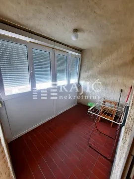 Enclosed balcony with a clothes drying rack. - image 2