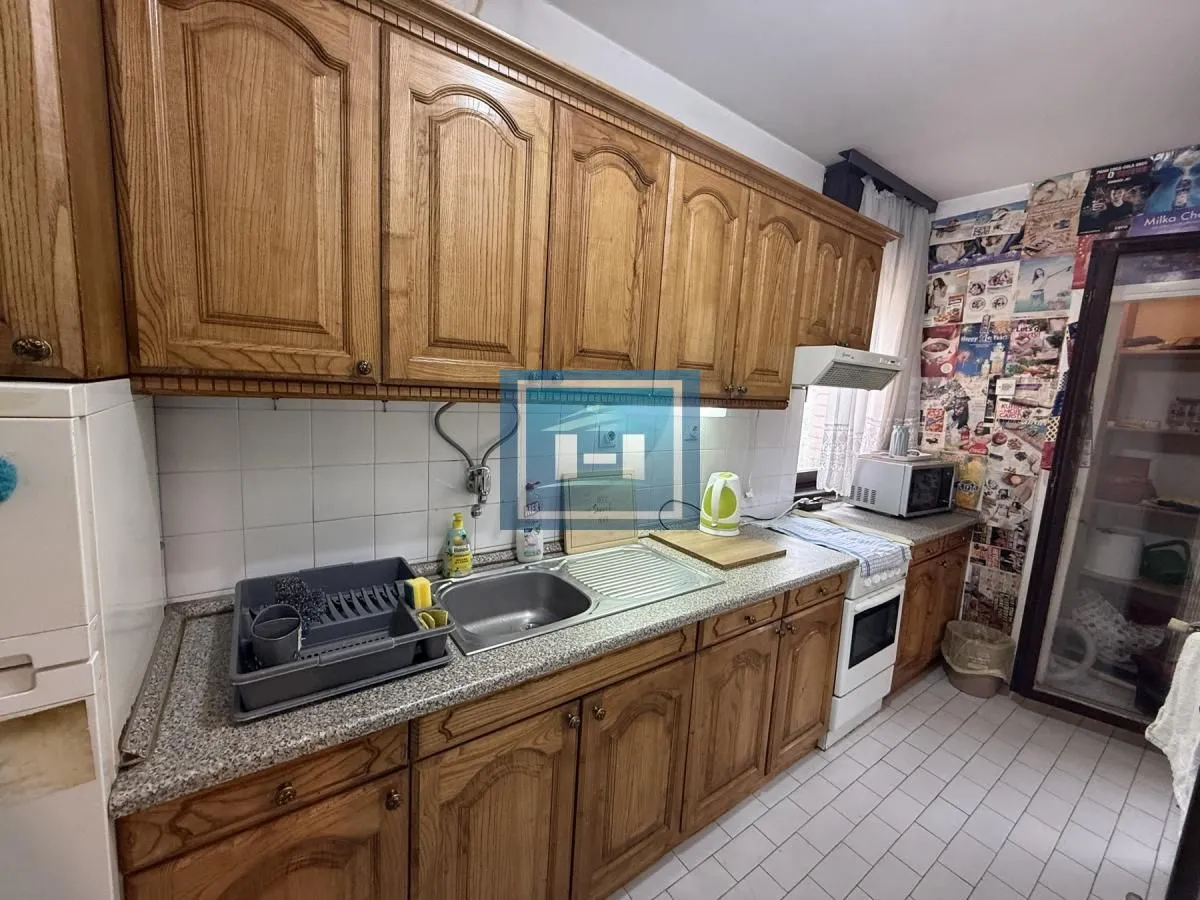 Kitchen with wooden cabinetry, sink, and stove.