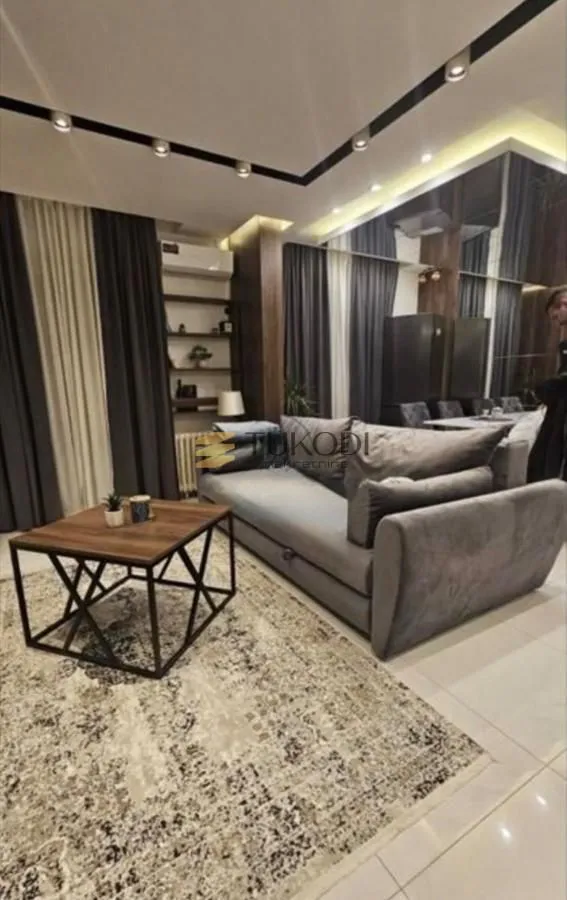 Living room with a sofa, coffee table, and modern lighting.
