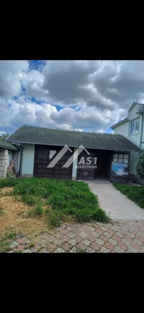 Exterior view of an outbuilding with garage doors and a grassy yard.