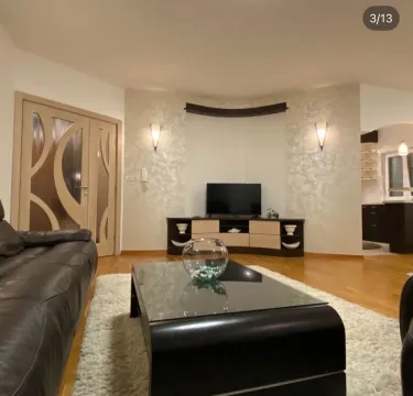 Spacious living room with a sofa, coffee table, and TV unit. - image 3