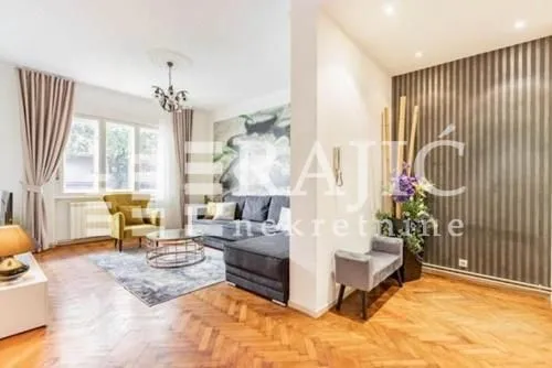 Furnished living room with a sofa and parquet flooring.