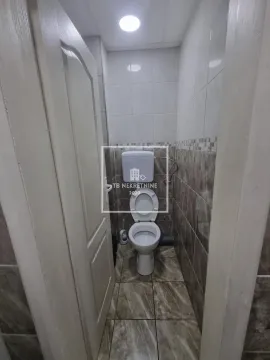 Small bathroom with ceramic tiles and toilet. - image 17