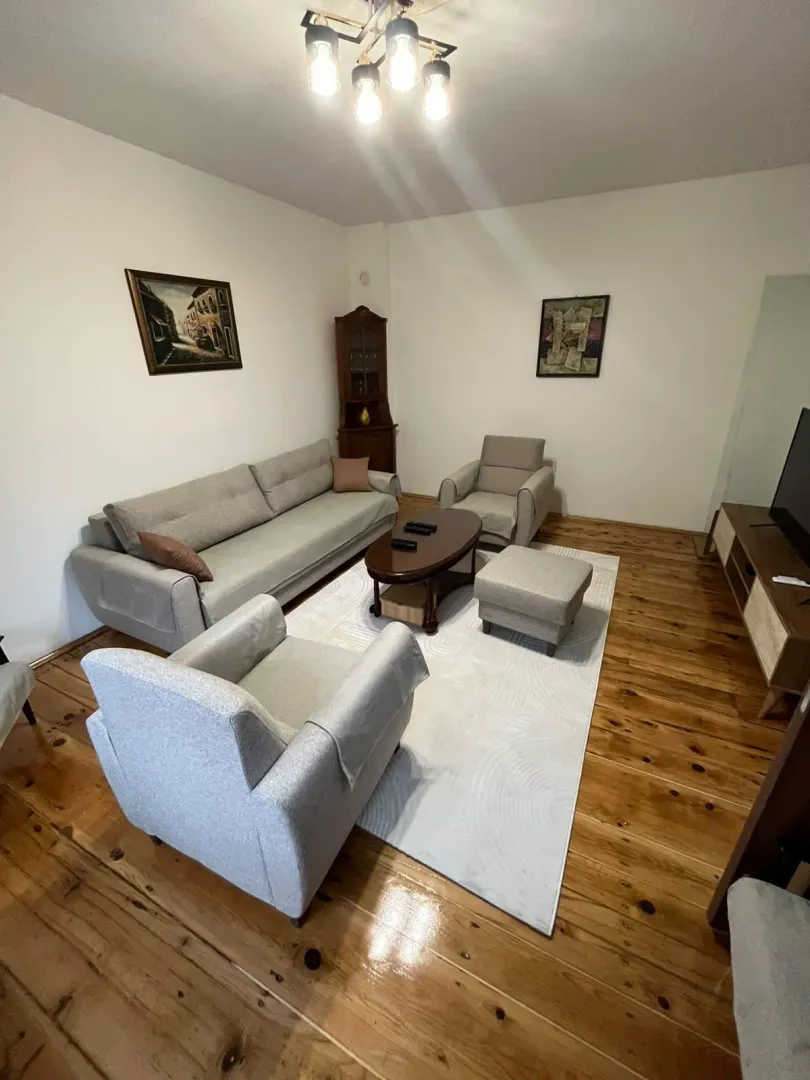 Living room with a sofa set, coffee table, and wooden flooring.