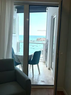 View from the terrace towards the town and the sea through open balcony doors. - image 4