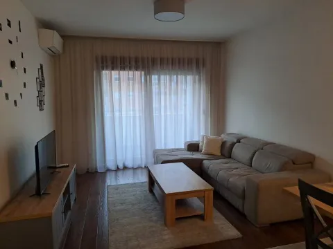 Living room with a corner sofa, television, and dining table. - image 7