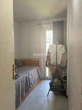 Small bedroom with a bed and a clothing rack. - image 8
