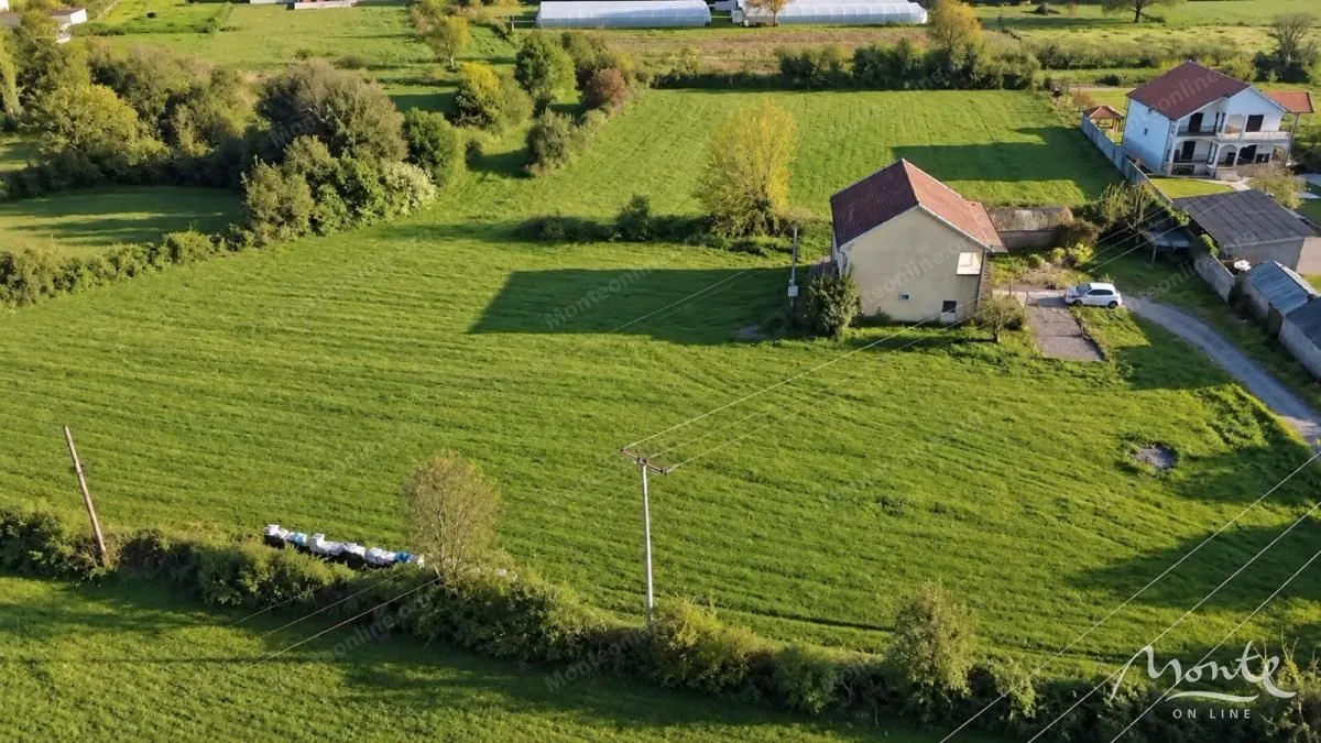Pogled iz vazduha na kuću sa velikim placem pod travnjakom.