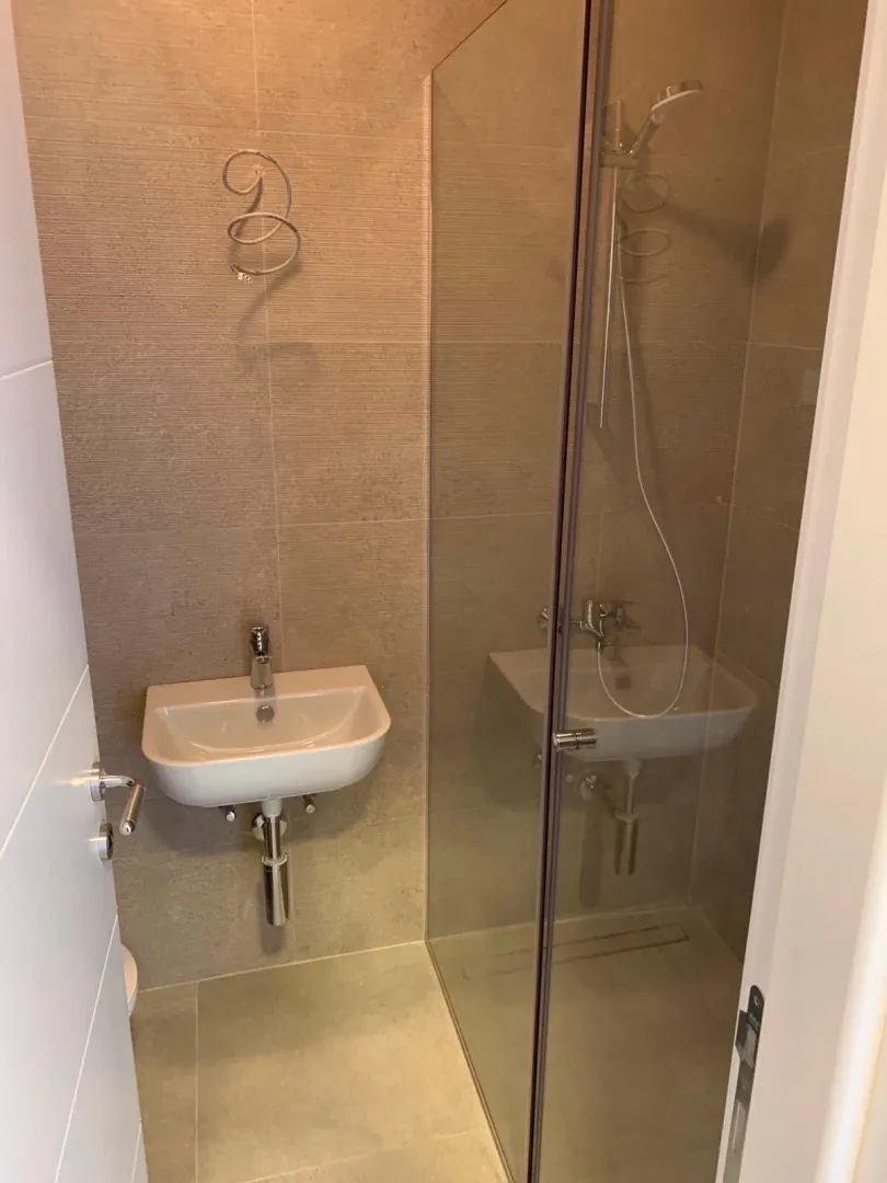 Small bathroom with a shower cabin and a washbasin.