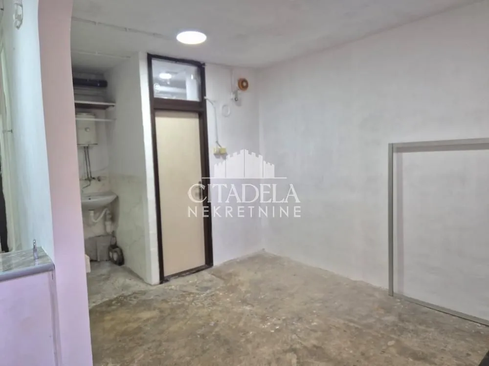 Empty room with light walls and a door leading to another space.