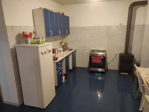 A simple kitchen with blue cabinets, a refrigerator, and a stove. - image 2