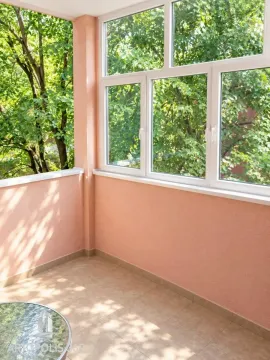 Zastakljeni balkon sa pogledom na zeleno drveće. - image 8