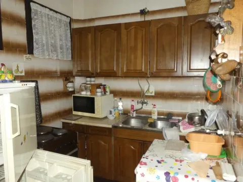 Older kitchen with wooden cabinets and a sink. - image 18