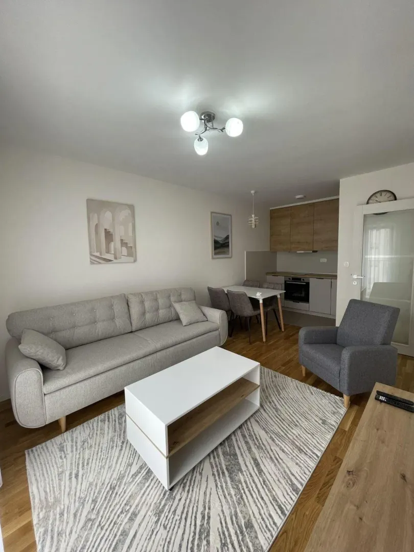 Living room with a sofa, coffee table, and an adjacent dining area.