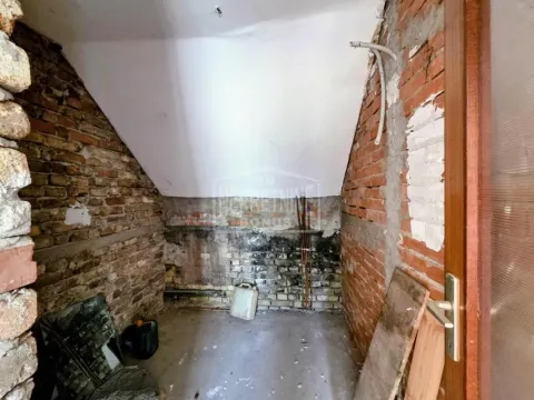 Prikaz prostorije u grubim radovima sa zidovima od cigle i kosim plafonom. - image 3