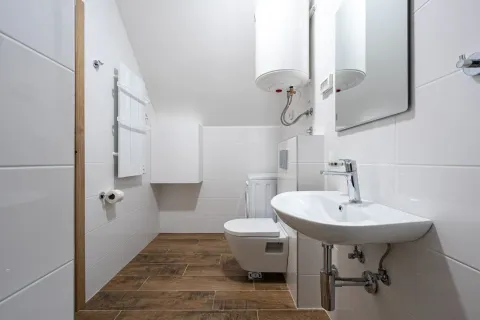 Manje kupatilo sa bijelim pločicama, umivaonikom i wc šoljom. - image 4