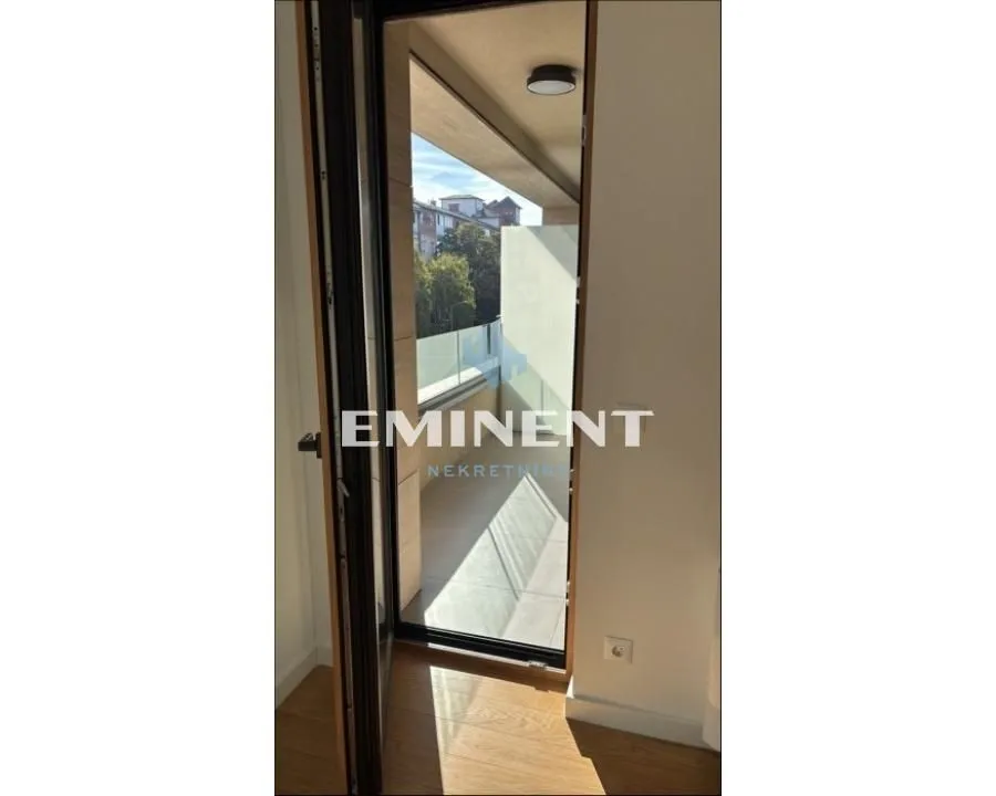 View through an open door to the balcony with a glass railing.