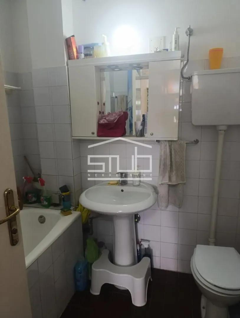 Small bathroom with a sink, toilet, bathtub, and mirrored cabinet.