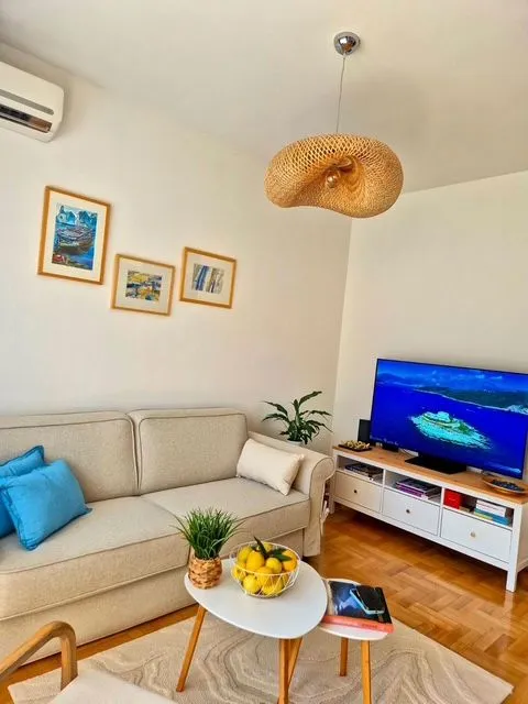 Living room with a sofa, TV, and decorative details.