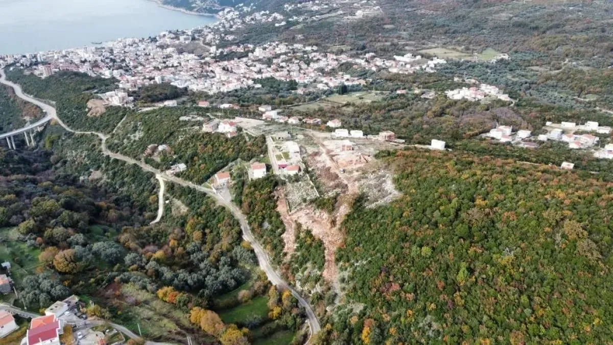 Pogled iz vazduha na lokaciju nekretnine sa okolnim pejzažom i naseljem.